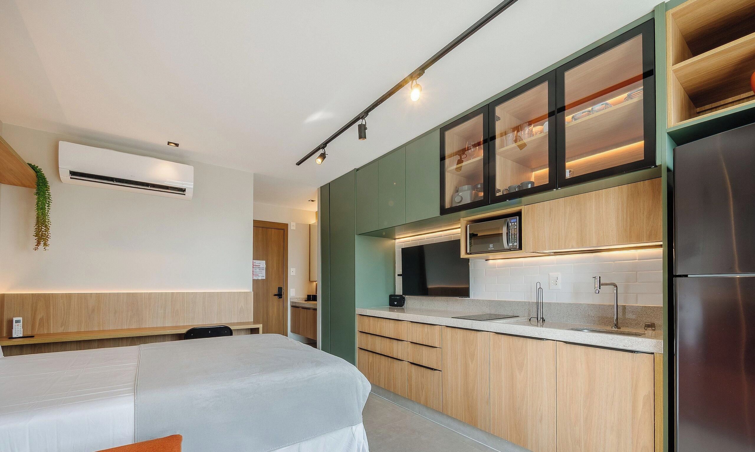 Eine moderne Küche mit Einbau-Mikrowelle, einem Edelstahl-Kühlschrank und einer Holz Arbeitsplatte.