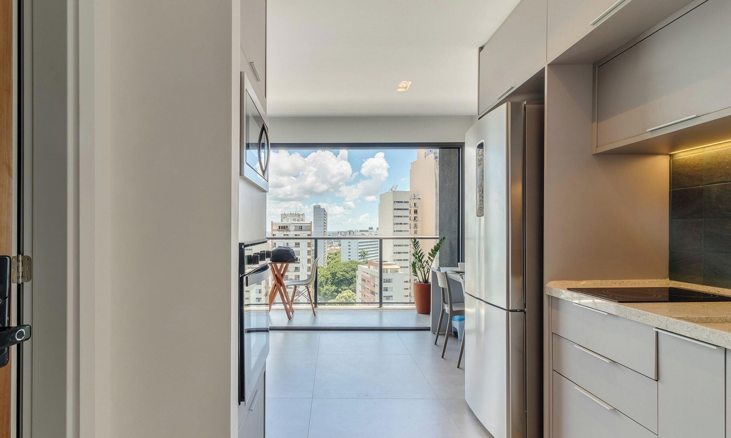 Una cocina moderna con balcón, comedor y vistas a la ciudad.