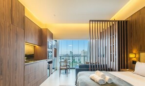 A modern hotel room with a large bed, a desk, and a view of the city. - Stay With Style and Convenience in Salvador LIV (Salvador)