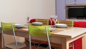 A dining area with a wooden table, green chairs, and red cushions. - Milano 27 - Two Bedroom Apartment, Sleeps 4 (Bormio)