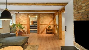 Una sala de estar moderna con un sofá, una mesa de centro, un televisor y una escalera que lleva a otra habitación.
