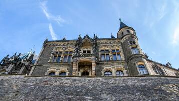 Ein historisches Gebäude mit einem markanten Turm, Rundbogenfenstern und aufwendiger Steinmetarbeit.