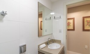 A bathroom with a sink, mirror, towel, and framed floral artwork on the wall. - Apart With Barbecue 100m From the Beach Don0504 (Balneário Camboriú)