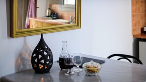 A table with a candle, a bottle, and a glass. - Aeolos Apartments (Santorini)