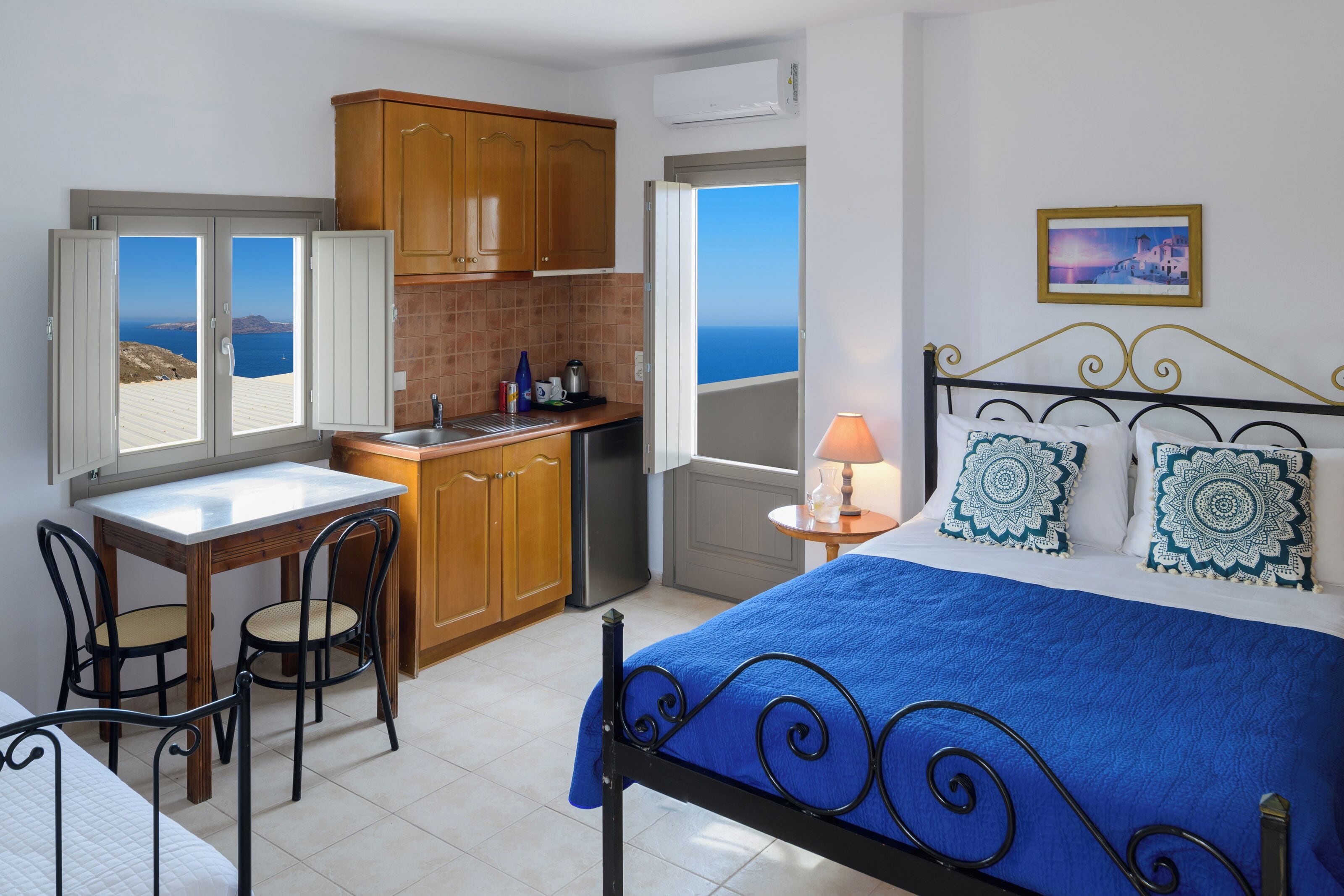 Un dormitorio con cama, escritorio y vista al mar.
