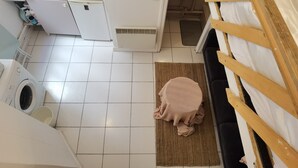Une cuisine de taille réduite équipée d’un lave-linge, d’un évier et d’un petit réfrigérateur.