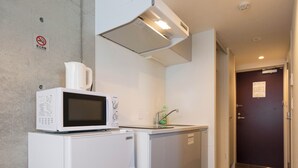 A compact kitchen with a microwave, refrigerator, and sink.