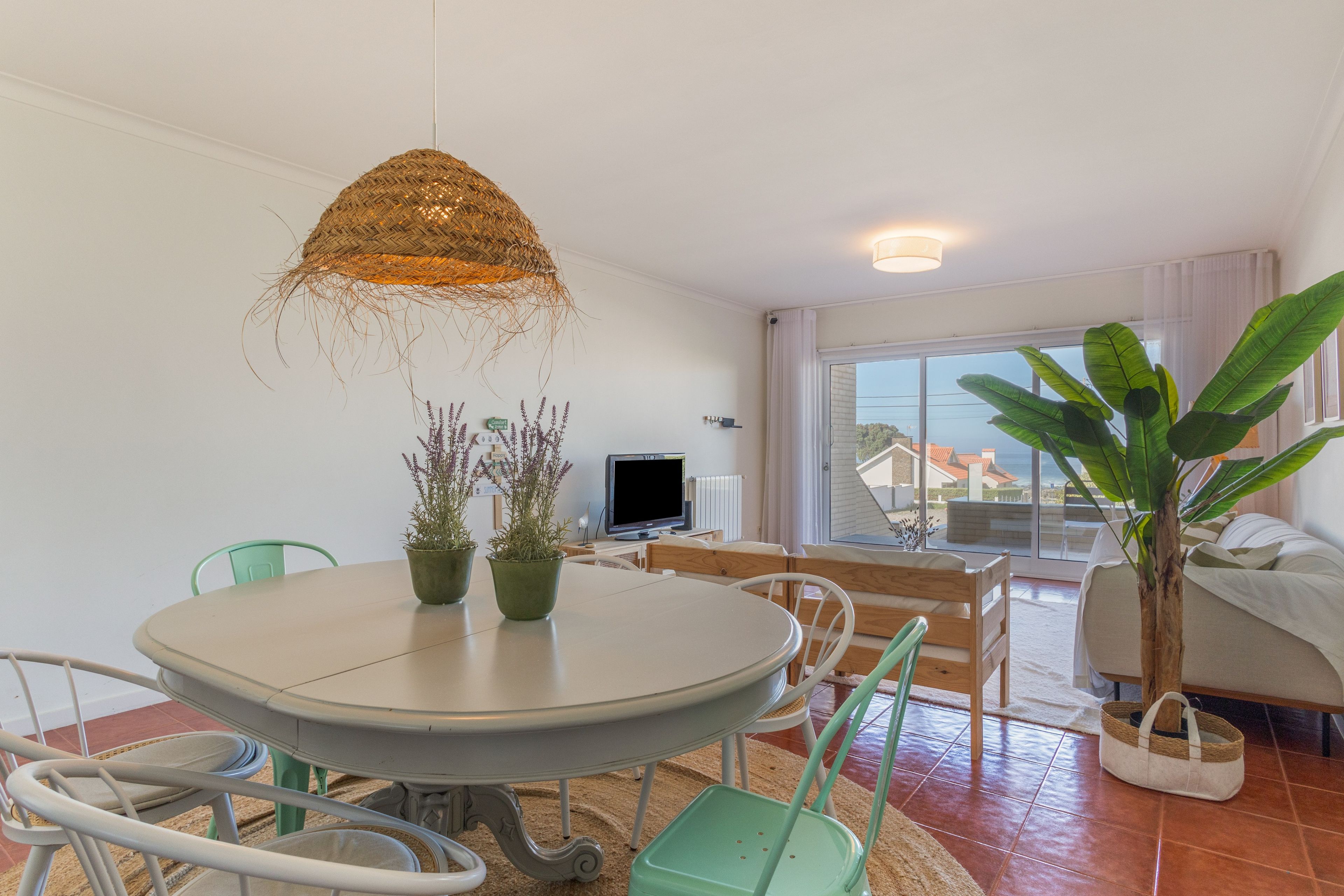 Una sala de estar moderna con comedor, un ventanal y vistas al exterior.