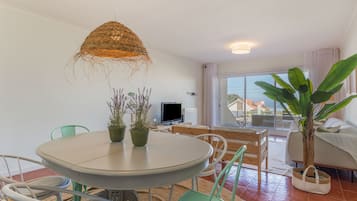 Una sala de estar moderna con comedor, un ventanal y vistas al exterior.