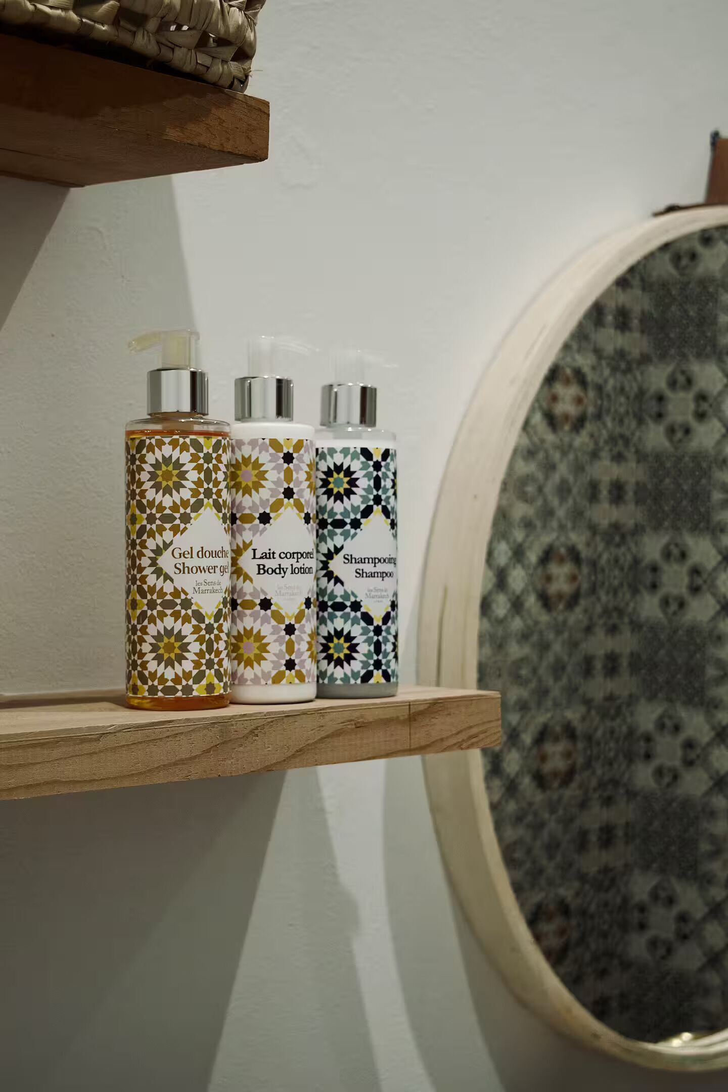 Three toiletry bottles on a wooden shelf.