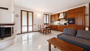 A living room with a sofa, a wooden coffee table, and a fireplace. - Apartment 'Lago' with Mountain View, Private Terrace and Wi-Fi (Dongo)