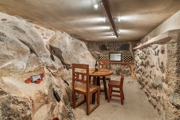 Un comedor rústico con paredes de piedra, muebles de madera y un letrero que dice 'Villa Bandama Golf'.