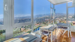 A room with large windows, wooden furniture, and a view of a valley. - Villa bandama golf Artenara Suite-02 with sea views, Wi-Fi and air conditioning (santa brigida)