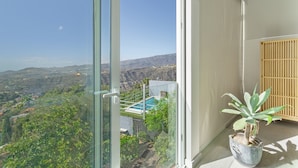 A balcony with a view of a mountainous landscape, a potted plant, and a wooden screen. - Villa bandama golf Artenara Suite-02 with sea views, Wi-Fi and air conditioning (santa brigida)
