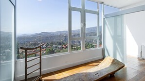 Ein Zimmer mit großen Fenstern, einer hölzernen Bank und einer Leiter.