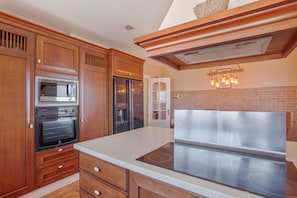 Una cocina con armarios de madera, estufa de acero inoxidable y microondas.