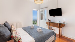 A bedroom with a bed, a bedside table, a TV, and a window with a view. - 'Villa bandama golf Tejeda-07' with sea views, Wi-Fi and air conditioning (santa brigida)