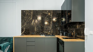 Una cocina moderna con protector mural de mármol, electrodomésticos integrados y suelo con estampado de espiga.