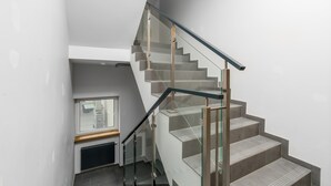 Una escalera moderna con barandillas de vidrio y un diseño minimalista.