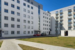 Ein modernes, mehrgeschossiges Wohngebäude mit schlichter Fassade, großen Fenstern und Balkonen.
