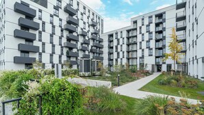 A modern apartment complex with balconies, a central pathway, and landscaped gardens. - Modern Apartment in Poznan | Balcony, Parking (Poznań)