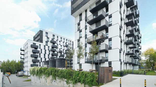 A modern apartment building with balconies and a paved walkway. - Modern Apartment in Poznan | Balcony, Parking (Poznań)