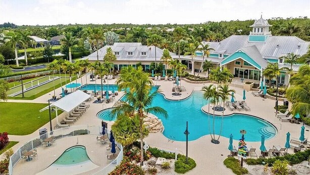 A resort with a large central pool, multiple smaller pools, and a variety of outdoor seating areas.