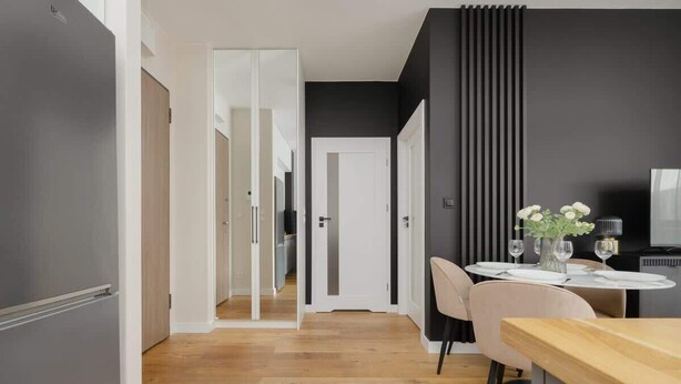 A modern kitchen with a wooden countertop and a dining area with a round table and chairs.