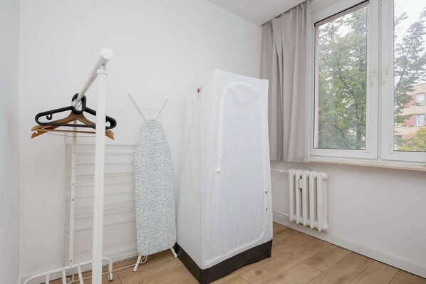 Une pièce équipée d’un radiateur, d’un étendoir et d’une armoire.