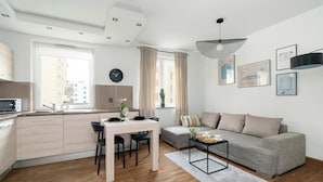 A modern apartment with a kitchen, dining area, and living room.