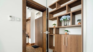 A wooden cabinet with multiple shelves, a door, and a small potted plant.