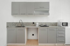 Kylskåp, mikrovågsugn, spishäll och grytor/köksredskap