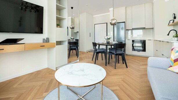 Una sala de estar moderna con una mesa de mármol, un sofá y un comedor con sillas.
