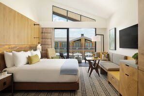 A modern hotel room with a large bed, a sofa, a dining table, and a TV. - Appellation Healdsburg (Healdsburg)