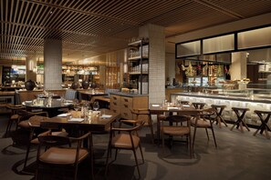 A modern restaurant with wooden furniture, a bar area, and a kitchen visible in the background. - Appellation Healdsburg (Healdsburg)