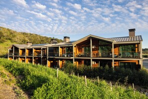 A modern multi-story house with large windows, a balcony, and a view of the surrounding greenery. - Appellation Healdsburg (Healdsburg)