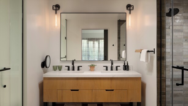 A modern bathroom with a wooden vanity, two sinks, a large mirror, and a glass shower enclosure. - Appellation Healdsburg (Healdsburg)