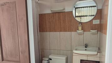 Habitación estándar con 1 cama matrimonial o 2 individuales | Baño | Regadera, toallas, jabón, shampoo