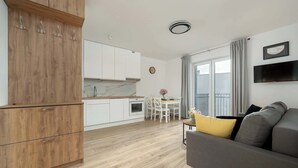 A modern apartment with a kitchen, dining area, and living room. - Sunny Apartment with Balcony | Parking | Close to Park (Wrocław)
