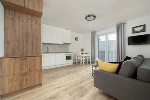 A modern apartment with a kitchen, dining area, and living room.