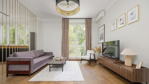 A modern living room with a sofa, coffee table, TV, and a wooden cabinet.