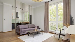 A modern living room with a sofa, coffee table, and a view of the kitchen.