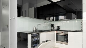 A modern kitchen with a dishwasher, oven, and black countertop.