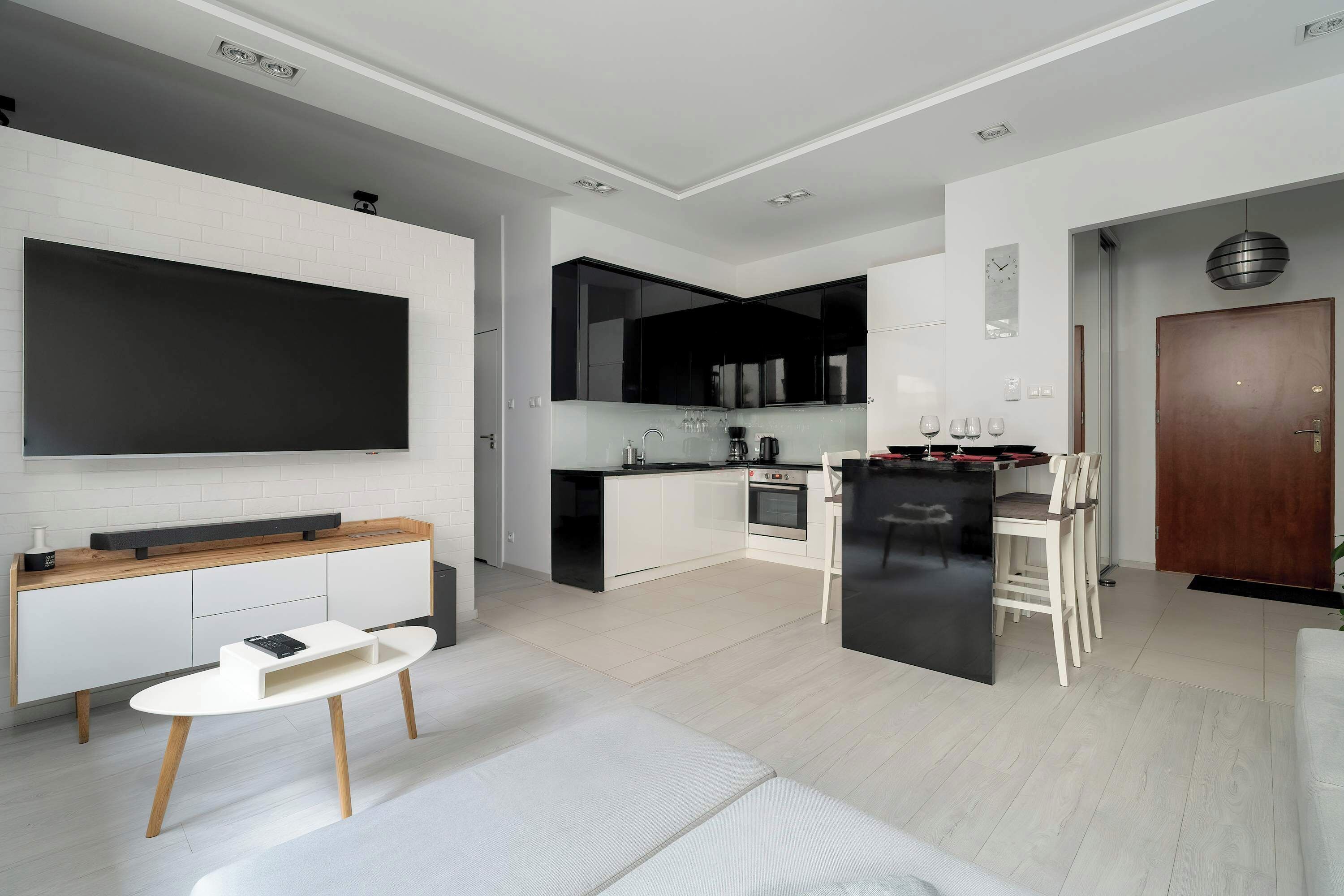 A modern kitchen with white cabinets, a black countertop, and a built-in oven.