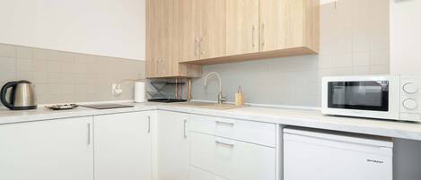 Kjøleskap, mikrobølgeovn, kokeplater og høy barnestol