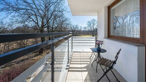 A balcony with a view of trees and a distant landscape.