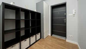 A room with a black shelving unit, a white door, and a white wall socket.