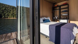 Un dormitorio con cama, armario y vistas a un lago.