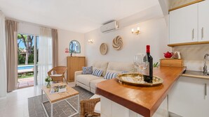 Ein modernes Wohnzimmer mit einer Couch, einem Esstisch und einer Küchenzeile mit Arbeitsplatte.