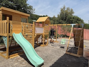 A playground with a slide, climbing wall, and swing set. - Family villa for 15 people with a playground, pool, and large hot tub! Ocean view!  (Tourrettes-sur-Loup)